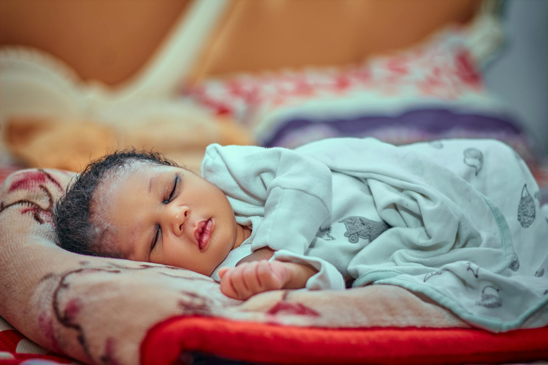 Śpiące niemowlę otulone miękkim kocem w przytulnym pokoju