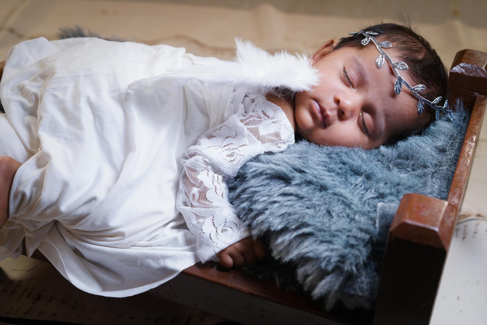 Śpiący noworodek oparty główką o miękką poduszkę