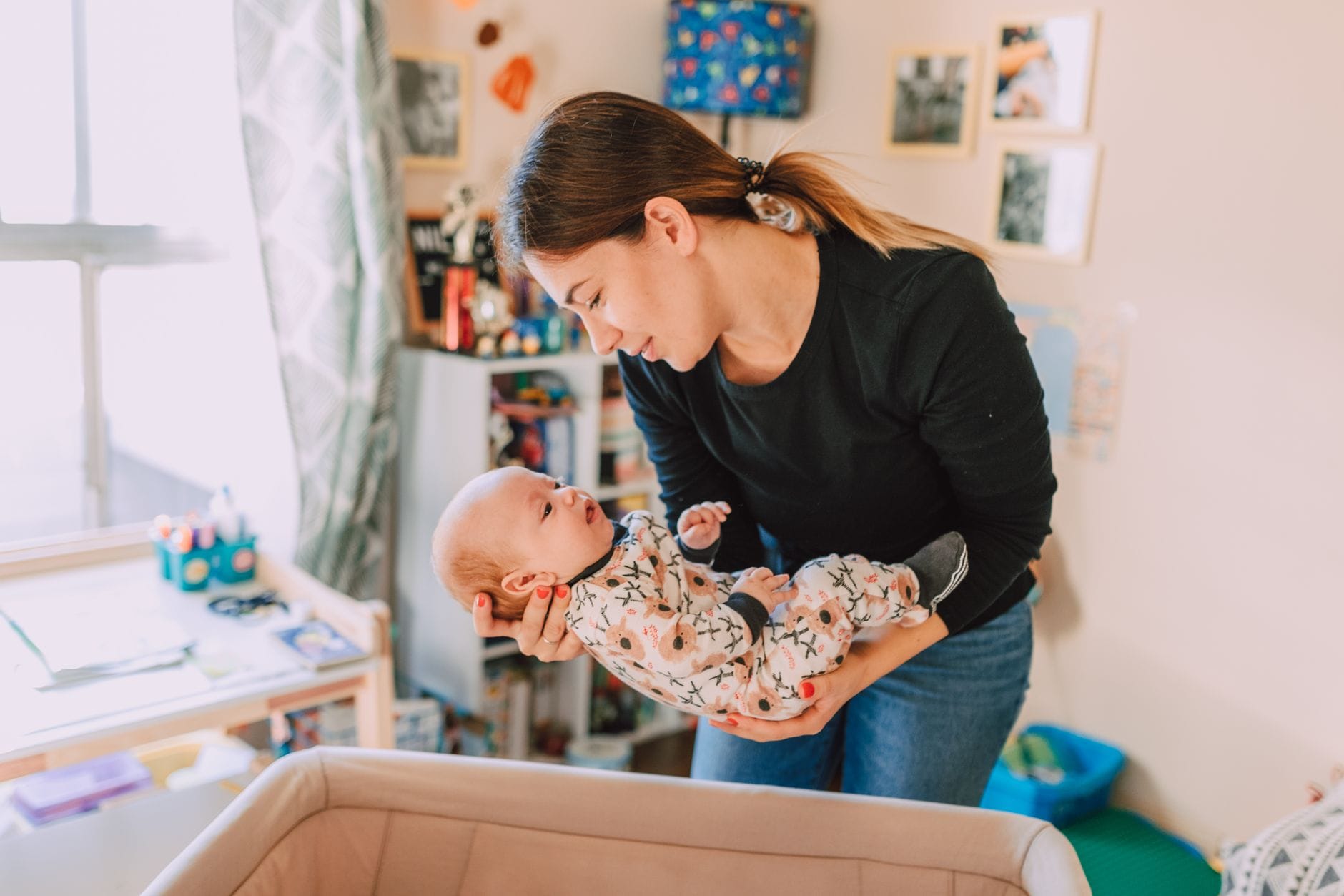 Mama trzyma śpiące niemowlę w przytulnym pokoju dziecięcym